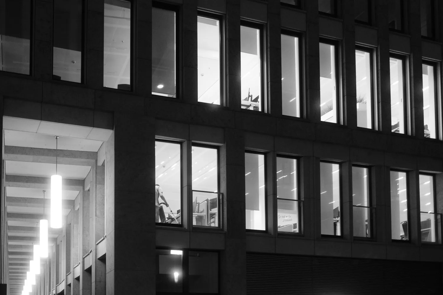 A grid of office windows at night, only some of them lit.