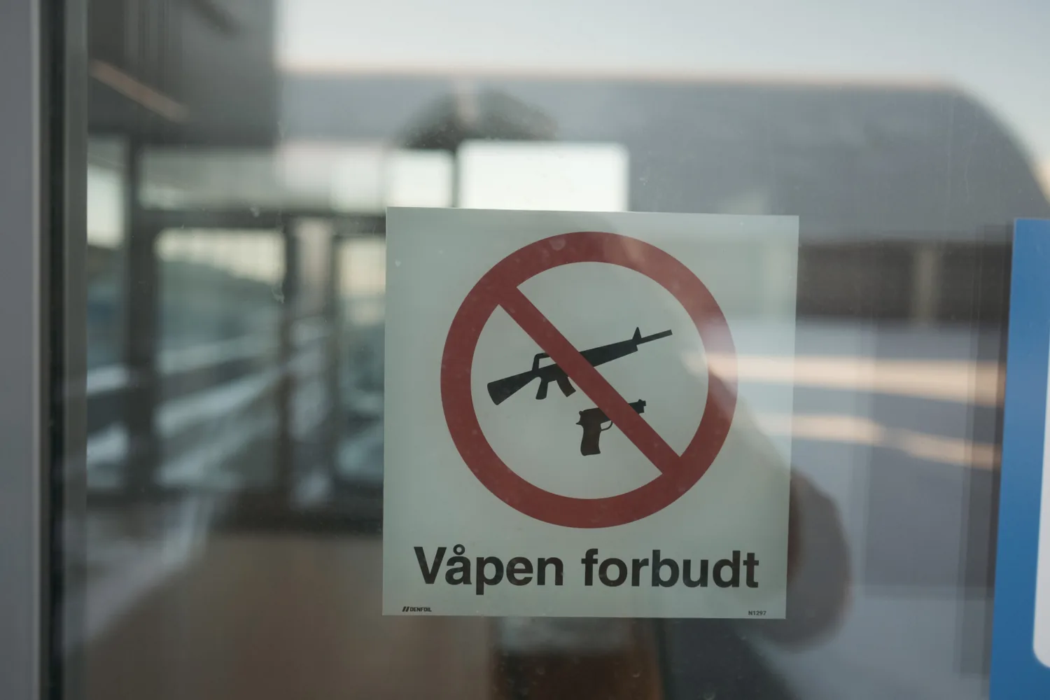 A 'weapons forbidden' sign with a rifle pictogram at the airport.